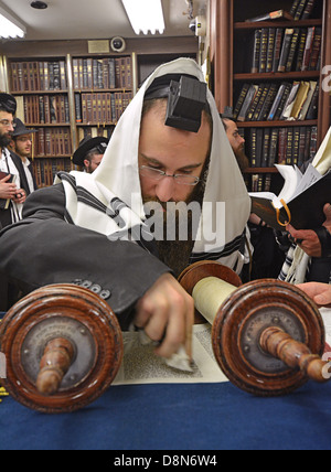 Un homme juif religieux bénit la Torah avant une lecture à des services en semaine au siège Loubavitch à Brooklyn, New York Banque D'Images