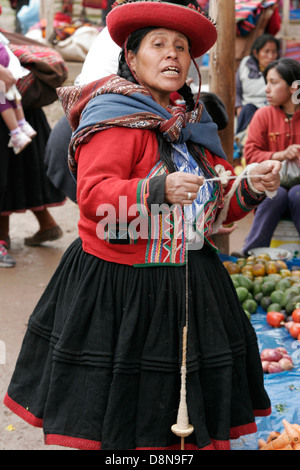 Femme Quechua filage de la laine à la main, vêtus de chapeau rond traditionnel sur les marché du dimanche de Chinchero près de Cuzco, Pérou Banque D'Images
