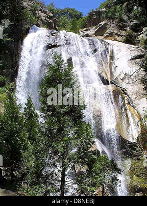 Une vue panoramique d'une cascade descendant des rochers, entourée d'une végétation luxuriante. Les cascades comme celles-ci sont des merveilles naturelles, fournissant à la fois beauté et écosystèmes vitaux pour diverses espèces. Banque D'Images