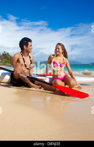 Couple sur la plage avec leur paddle boards Banque D'Images