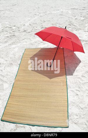 Parapluie rouge et bambou sur la plage Banque D'Images
