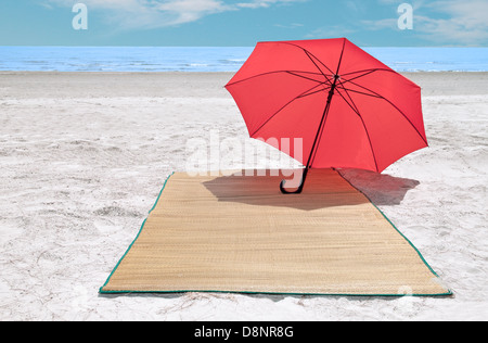 Parapluie rouge et bambou sur la plage Banque D'Images