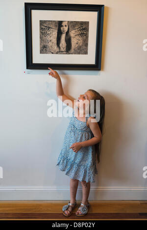 Huntington, New York, États-Unis 1er juin 2013. LILY CARLSON, 5, Rock Point, pointe vers une photo d'elle-même, "Uncaged" par Jennifer Carlson, à la réception d'ouverture de la 2013 "sous l'Influence' Student Exposition sur invitation. Sur l'affichage des images ont été de 29 étudiants d'instructeurs de l'fotofoto Galerie ; le lieu de l'événement. Credit : Ann E Parry/Alamy Live News Banque D'Images