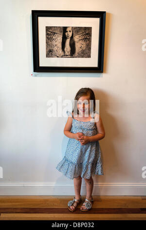 Huntington, New York, États-Unis 1er juin 2013. LILY CARLSON, 5, Rock Point, est sous une photo d'elle-même, "Uncaged" par Jennifer Carlson, à la réception d'ouverture de la 2013 "sous l'Influence' Student Exposition sur invitation. Sur l'affichage des images ont été de 29 étudiants d'instructeurs de fotofoto Gallery, le lieu de l'événement. Credit : Ann E Parry/Alamy Live News Banque D'Images