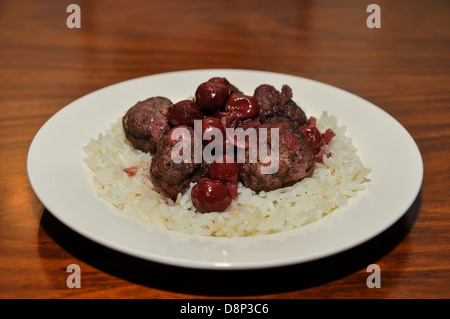 Une assiette de boulettes de viande à la sauce aux cerises sur le riz Banque D'Images