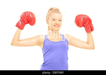 Athlète féminine souriante portant des gants de boxe et posant contre isolé sur fond blanc Banque D'Images