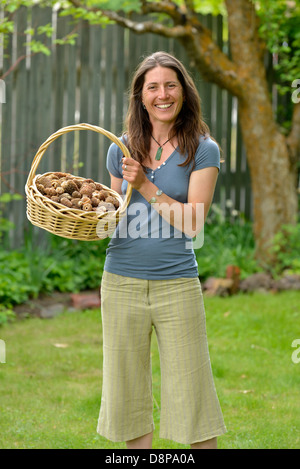 Femme tenant un panier de morilles de la Wallowa fraîchement récoltés, les montagnes de l'Oregon. Banque D'Images