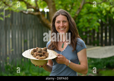 Femme tenant un panier de morilles de la Wallowa fraîchement récoltés, les montagnes de l'Oregon. Banque D'Images