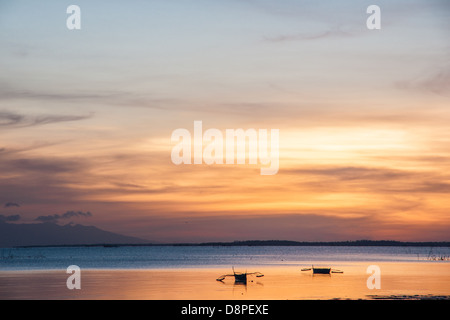 Deux outrigger bangkas - un bateau de pêche traditionnelle des Philippines - lulling dans le coucher du soleil Banque D'Images