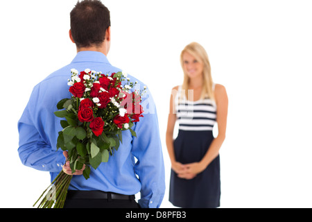 Young bouquet de roses derrière le dos de surprendre sa petite amie le jour de la Saint-Valentin Banque D'Images