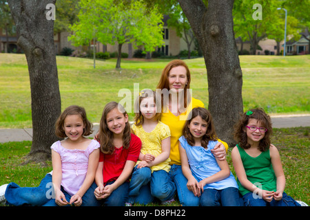 Mère fille avec l'enseignant les élèves dans le parc de jeux portrait de groupe sur la pelouse Banque D'Images