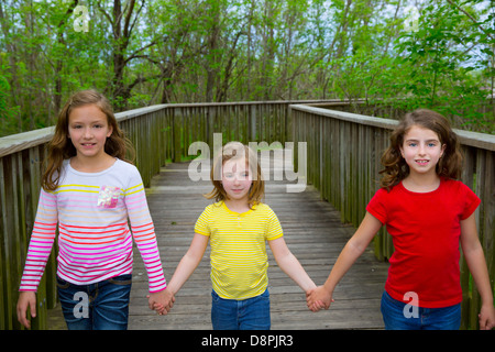 Soeur amis marchant main dans la main sur le lac bois smiling Banque D'Images