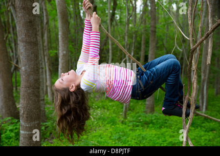 Les enfants filles jouant la pendaison et de l'escalade de lianes en forêt jungle park outdoor Banque D'Images