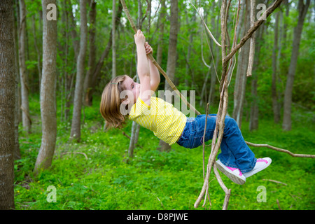 Les enfants filles jouant la pendaison et de l'escalade de lianes en forêt jungle park outdoor Banque D'Images