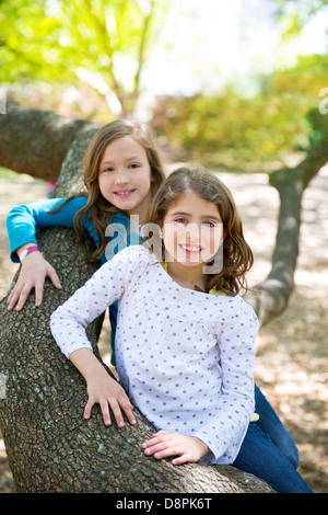 Sœur d'amis filles reposant sur tronc d'arbre nature plein air Banque D'Images