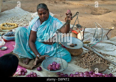 Femme indienne de l'oignons de pesage du vendeur au marché indien au Village de Moka, Madhya Pradesh, Inde Banque D'Images