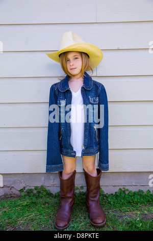 Petit enfant fille prétendant être un cowboy avec le père de bottes et de hat Banque D'Images