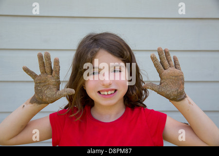 Happy kid fille jouant avec de la boue avec des mains sales smiling portrait Banque D'Images