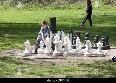 Jeune garçon jouant aux échecs par lui-même à Margam Country Park, le Pays de Galles, Royaume-Uni. Banque D'Images