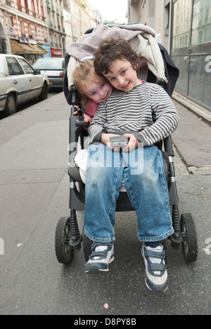 Jeunes enfants assis dans la poussette Banque D'Images