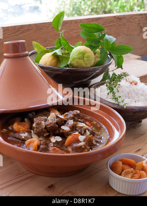 Tajine marocaine traditionnelle de carottes et de la viande bovine avec plats de riz blanc et les abricots séchés et un bol de citrons. Banque D'Images