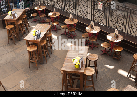 En bois vide tables chaises disposées en rangées à l'égard de l'acier forgé Banque D'Images