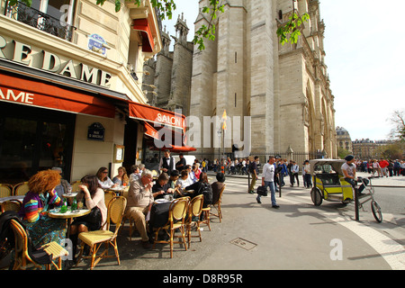 Cafe 'Aux Tours de Notre Dame', près de la cathédrale Notre-Dame, les gens bavarder autour d'un verre enjoing premier soleil du printemps à Paris, France Banque D'Images