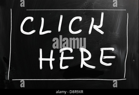 Cliquez ici à la main avec craie blanche sur un tableau noir Banque D'Images