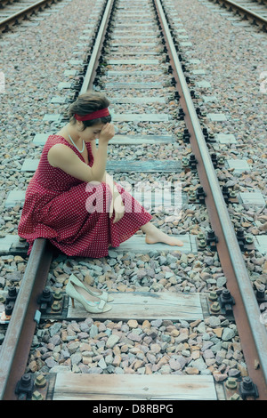 Une fille triste sur des rails de chemin de fer Banque D'Images