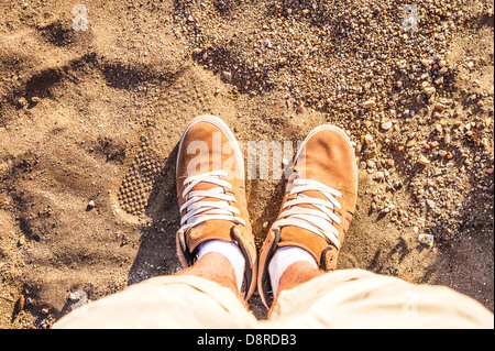 Paire de bottes Chaussures homme sur le pied d'une plage de sable du côté de la mer Vue de dessus de l'été loisirs créatifs en arrière-plan Banque D'Images