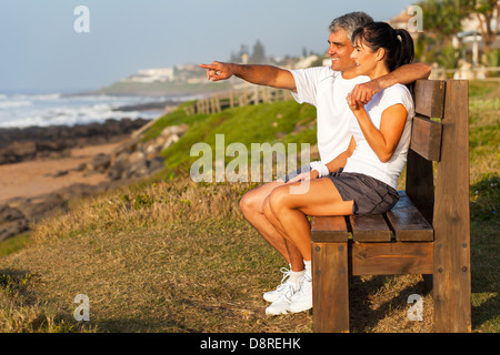 Mettre en place le mari et la femme d'âge moyen à la plage le matin Banque D'Images