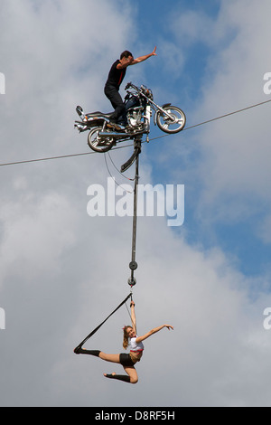 Moto stunt rider sur fil avec girl acrobat Albert Park Melbourne Australie Victoria Banque D'Images