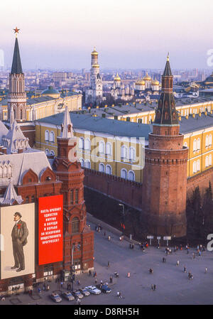 Le 1 mai, 1987 - Moscou, RU - des affiches géantes de Vladimir Lénine et de slogans soviétique décorer l'avant de l'histoire Musée sur la place de la révolution à Moscou pour le défilé annuel du mois de mai. Les piétons en bas, au centre, entre la Place Rouge passant au coin de la tour de l'Arsenal du Kremlin wall en face du musée. L'Arsenal du Kremlin est derrière la tour et le Nikolskaïa (St Nicolas), surmonté de la tour de l'étoile rouge, est à l'extrême gauche. Les dômes dorés de la cathédrales et églises du Kremlin peut être voir dans le centre historique. (Crédit Image : © Arnold Drapkin/ZUMAPRESS.com) Banque D'Images