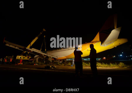 Davao, Philippines. 4 juin 2013. L'équipe de récupération d'équipage déposer la Cebu Pacific avion transportant 165 passagers a dépassé la piste de l'Aéroport International de Davao, 04 juin 2013. Les autorités de l'aviation Philippine arrêter l'un des aéroports les plus achalandés du pays le 2 juin, après un vol Cebu Pacific 5J 971 avion a atterri en toute sécurité mais comme "hors de la partie droite de la piste de l'Aéroport International de Davao pendant une averse lourde' sur la fin du 02 juin. Tous les 165 passagers sont sécuritaires et furent transportées à un terminal de l'aéroport, la compagnie aérienne a déclaré Crédit : Eli Ritchie Tongo/Alamy Live News Banque D'Images