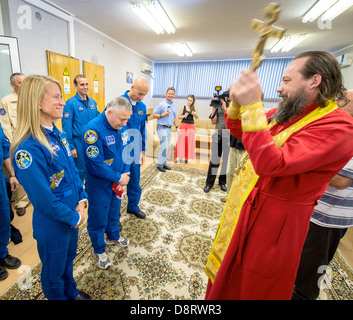 Expedition 36/37 ingénieur de vol de la NASA Karen Nyberg, gauche, commandant de Soyouz Fyodor Yurchikhin de l'Agence spatiale fédérale russe, centre, et l'ingénieur de vol Luca Parmitano de l'Agence spatiale européenne, de recevoir une bénédiction traditionnelle d'un prêtre orthodoxe, avant les trois membres d'équipage au départ de l'hôtel pour convenir à des cosmonautes et le lancement à bord d'un vaisseau Soyouz à la Station spatiale internationale le 28 mai 2013 à Baïkonour au Kazakhstan. Banque D'Images