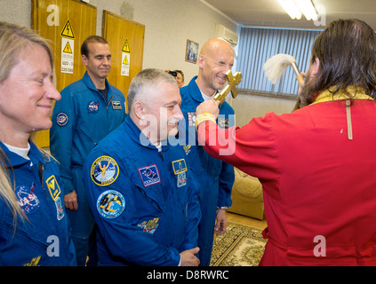 Expedition 36/37 ingénieur de vol de la NASA Karen Nyberg, gauche, commandant de Soyouz Fyodor Yurchikhin de l'Agence spatiale fédérale russe, centre, et l'ingénieur de vol Luca Parmitano de l'Agence spatiale européenne, de recevoir une bénédiction traditionnelle d'un prêtre orthodoxe, avant les trois membres d'équipage au départ de l'hôtel pour convenir à des cosmonautes et le lancement à bord d'un vaisseau Soyouz à la Station spatiale internationale le 28 mai 2013 à Baïkonour, au Kazakhstan. Banque D'Images