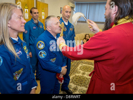 Expedition 36/37 ingénieur de vol de la NASA Karen Nyberg, gauche, commandant de Soyouz Fyodor Yurchikhin de l'Agence spatiale fédérale russe, centre, et l'ingénieur de vol Luca Parmitano de l'Agence spatiale européenne, de recevoir une bénédiction traditionnelle d'un prêtre orthodoxe, avant les trois membres d'équipage au départ de l'hôtel pour convenir à des cosmonautes et le lancement à bord d'un vaisseau Soyouz à la Station spatiale internationale le 28 mai 2013 à Baïkonour au Kazakhstan. Banque D'Images