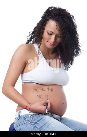 Pregnant Caucasian woman avec de beaux cheveux bouclés, assis dans les derniers jours de dessin profil gauche. Banque D'Images