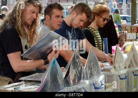 Les jeunes hommes à la recherche d'occasion à long-player albums de brocante en ville en été Banque D'Images