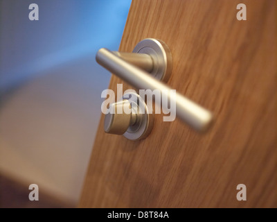 Poignée de porte d'argent et de verrou sur une porte en bois brun Banque D'Images