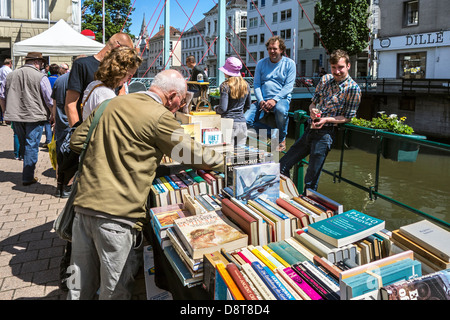 Un homme âgé d'occasion d'acheter des livres d'occasion sur le stand au marché du livre Ajuinlei à Gand, Belgique Banque D'Images