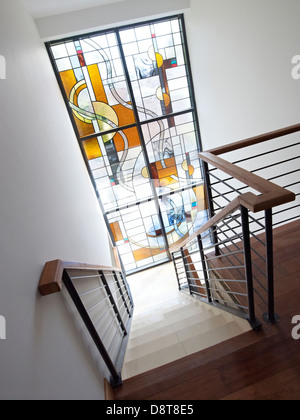 Escalier avec main courante et une fenêtre en verre teinté Banque D'Images