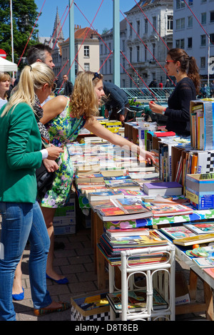 Les femmes d'acheter des livres usagés à vendre au stand au marché du livre Ajuinlei à Gand, Belgique Banque D'Images