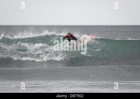 La plage de FISTRAL, Newquay, CORNWALL, UK. Femme inconnue surfer une vague dans la mer à la plage de Fistral. Banque D'Images