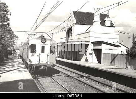 Cette photographie en noir et blanc de 1971 montre la gare ferroviaire d'Emu Plains, située sur la Blue Mountains Line en Nouvelle-Galles du Sud. L'image capture un moment dans le temps avec un train dans la gare, montrant l'importance historique de l'emplacement et de l'infrastructure de transport dans la région. Banque D'Images