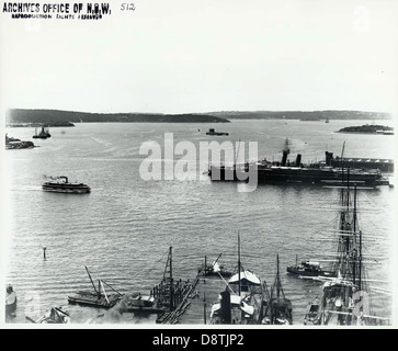 Cette photographie historique en noir et blanc capture une vue panoramique du port de Sydney depuis Dawes point, prise au début du XXe siècle. L'image met en valeur le port animé, des monuments emblématiques tels que l'Opéra de Sydney et le pont du port de Sydney, et l'activité de navigation dynamique qui a défini le patrimoine maritime de la ville portuaire. Banque D'Images