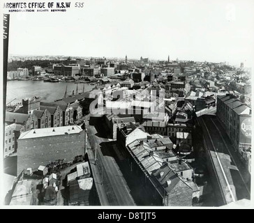 Cette image en noir et blanc capture une vue panoramique depuis George Street, surplombant Circular Quay à Sydney. Il met en évidence le port animé et le paysage urbain de la région, mettant en valeur son importance historique et son développement urbain. Banque D'Images