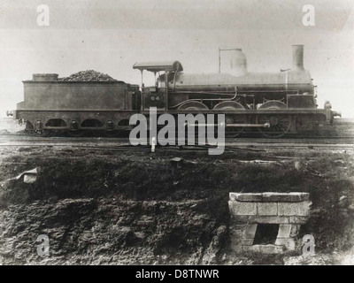 La locomotive Class O-60 No.64 est une locomotive à vapeur historique datant du début du XXe siècle, autrefois utilisée pour le transport ferroviaire en Nouvelle-Galles du Sud. Cette photographie en noir et blanc met en valeur le design et les caractéristiques techniques de la locomotive, un élément clé de l’histoire industrielle de la région. Banque D'Images