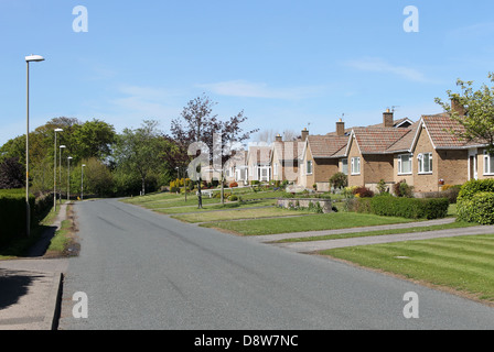 Rue de maisons bungalow dans village anglais. Banque D'Images