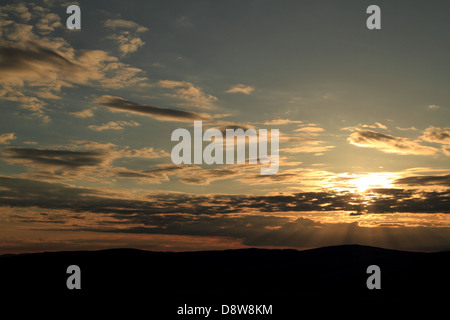 La lumière dorée du coucher du soleil, avec les rayons du soleil qui traverse les nuages. Lennoxtown, Glasgow, Écosse, Royaume-Uni Banque D'Images